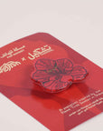 Tashkeel Flame Tree Pop Socket attached to a smartphone, featuring a vibrant flame tree design for enhanced grip and style.