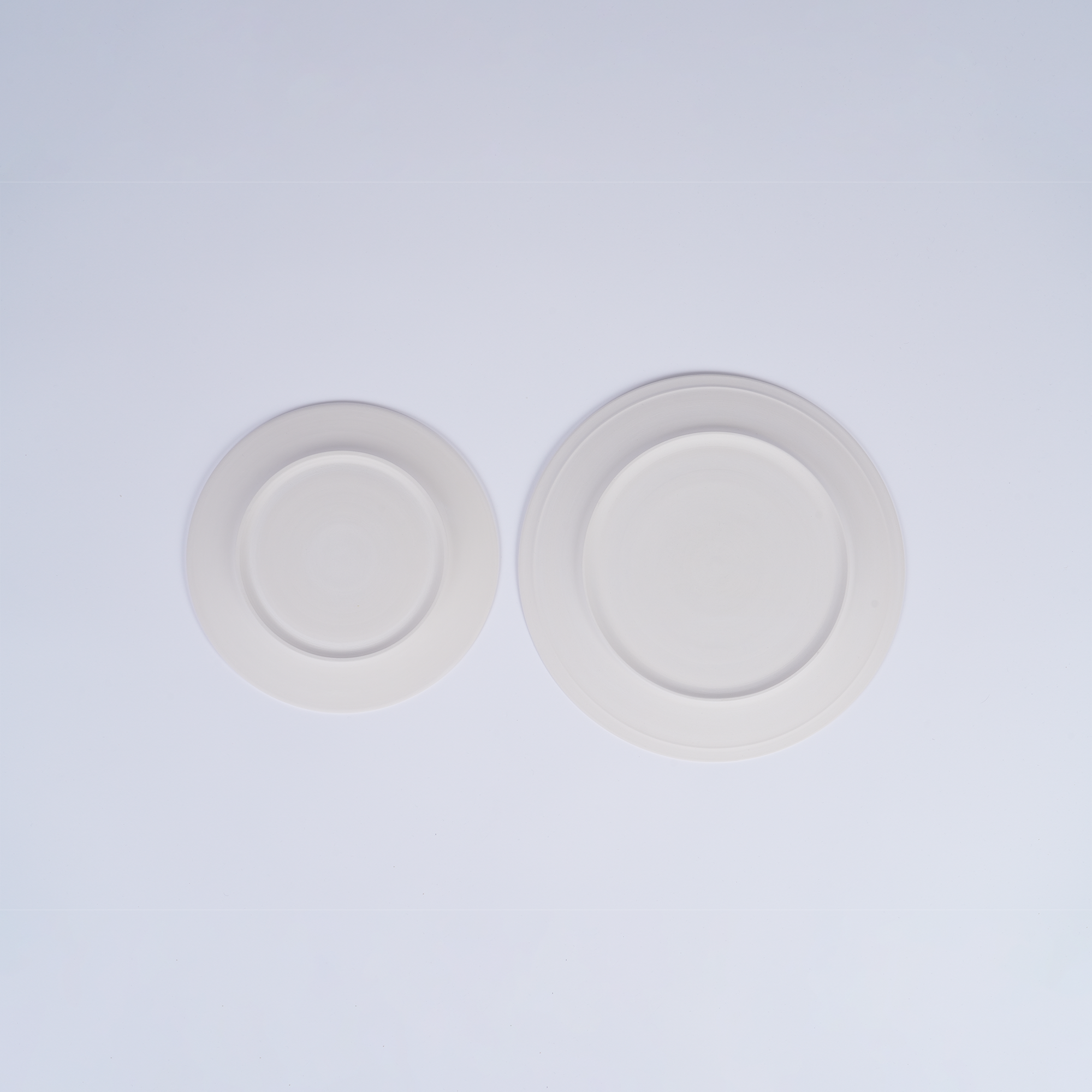 Tashkeel ceramic bisque plate with smooth, unglazed finish and round shape, showcasing a handcrafted, matte surface.