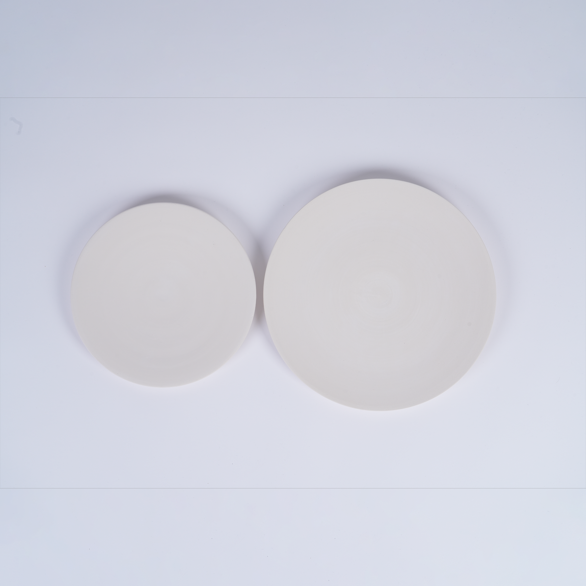 Tashkeel ceramic bisque plate with smooth, matte finish and round shape, showcasing detailed craftsmanship on a neutral background.