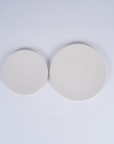 Tashkeel ceramic bisque plate with smooth, matte finish and round shape, showcasing detailed craftsmanship on a neutral background.