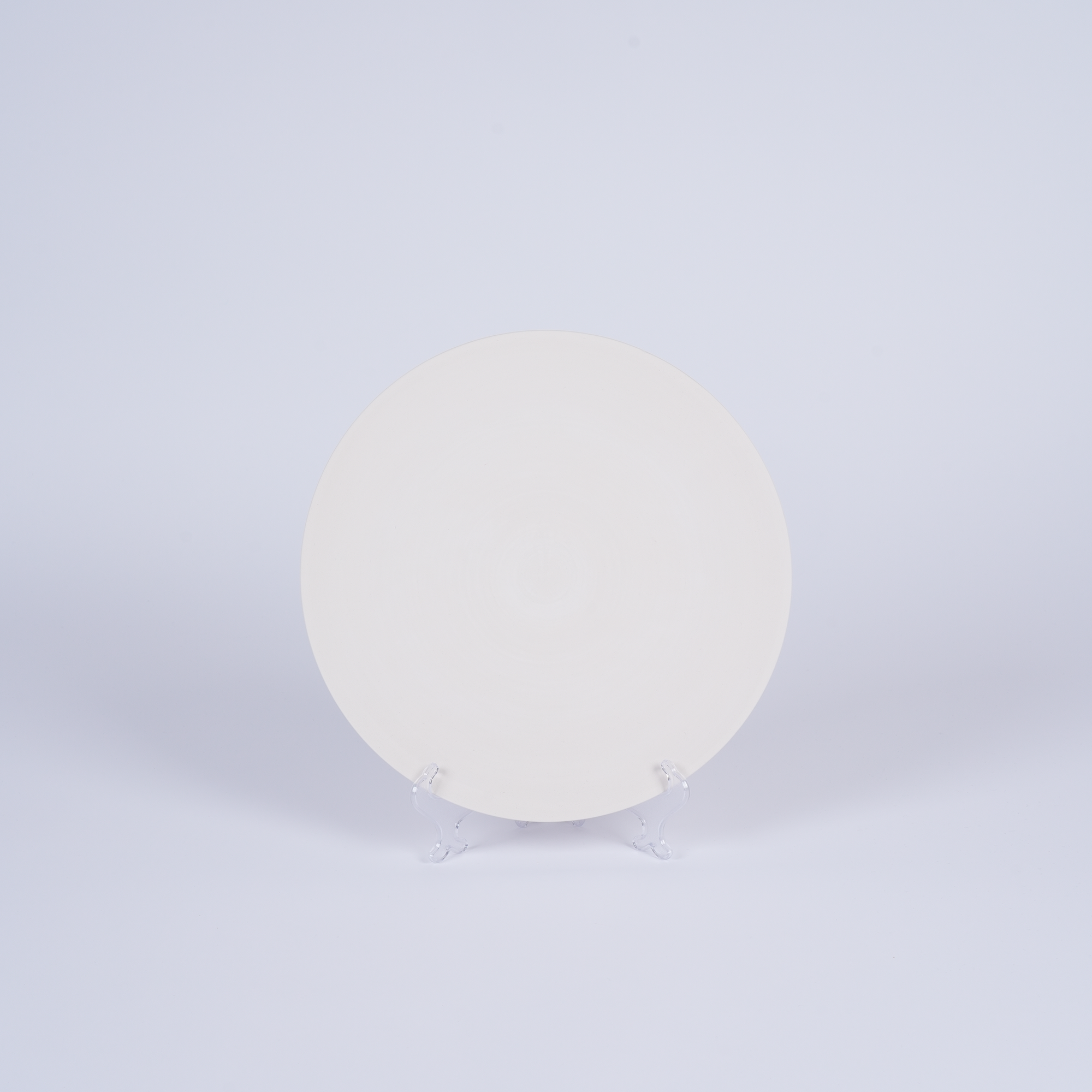 Tashkeel ceramic bisque plate with smooth, unglazed surface and rounded edges, showcasing a classic, handcrafted design.